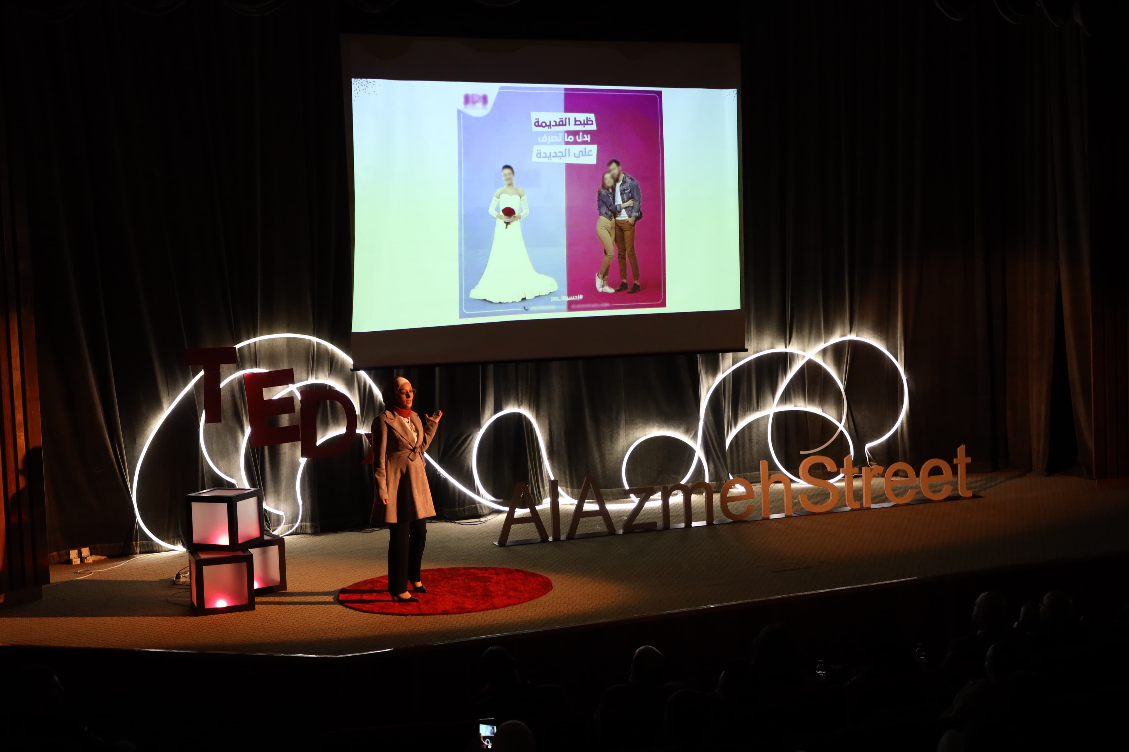 Nada speaking on the TEDx AlAzmeh Street stage