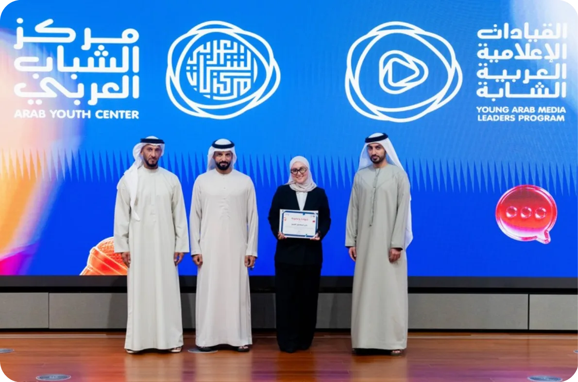 Nada receiving her certificate on stage at the Arab Youth Center