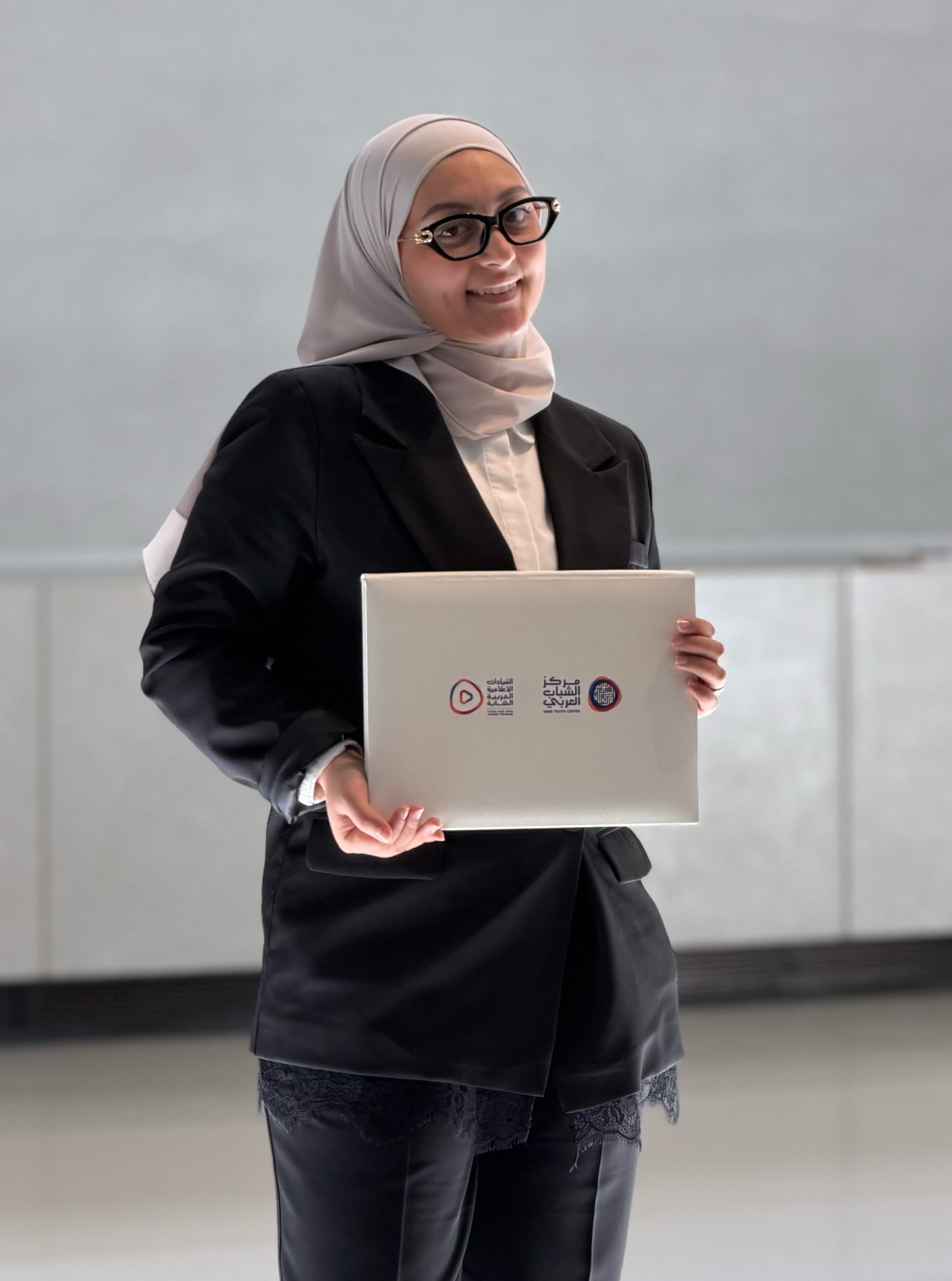 Nada holding her Young Arab Media Leaders certificate